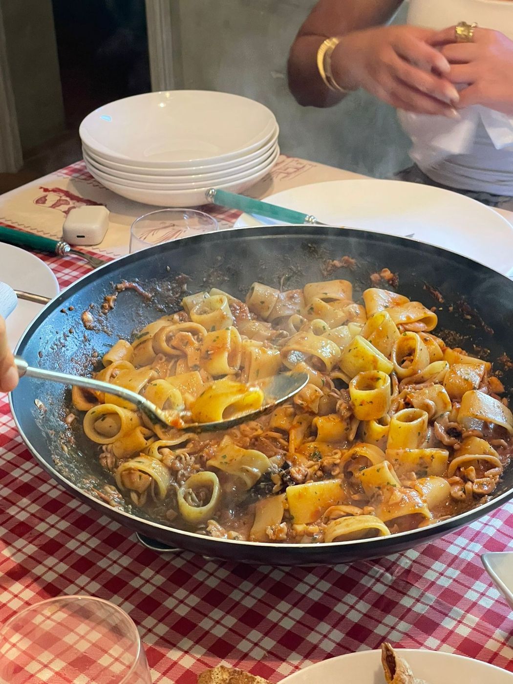 A pan of paccheri served at a family table
