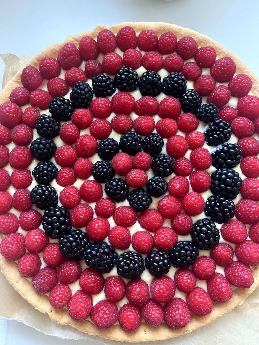 A tart topped with raspberries and blackberries