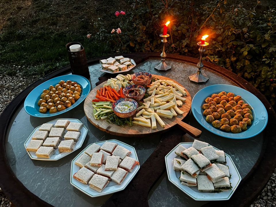 An aperitivo spread on a garden table by candlelight