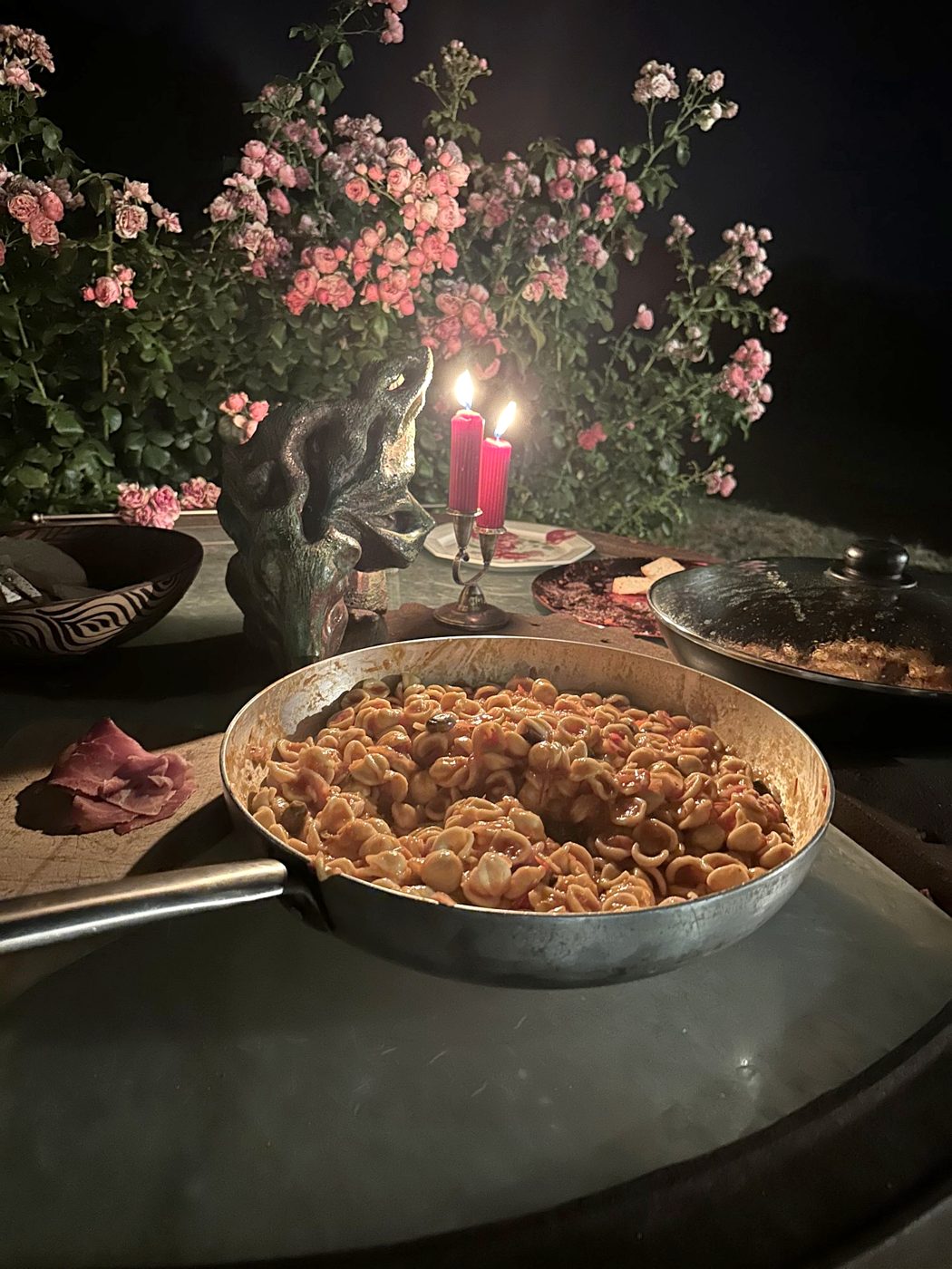Orecchiette served by candlelight on a terrace among roses